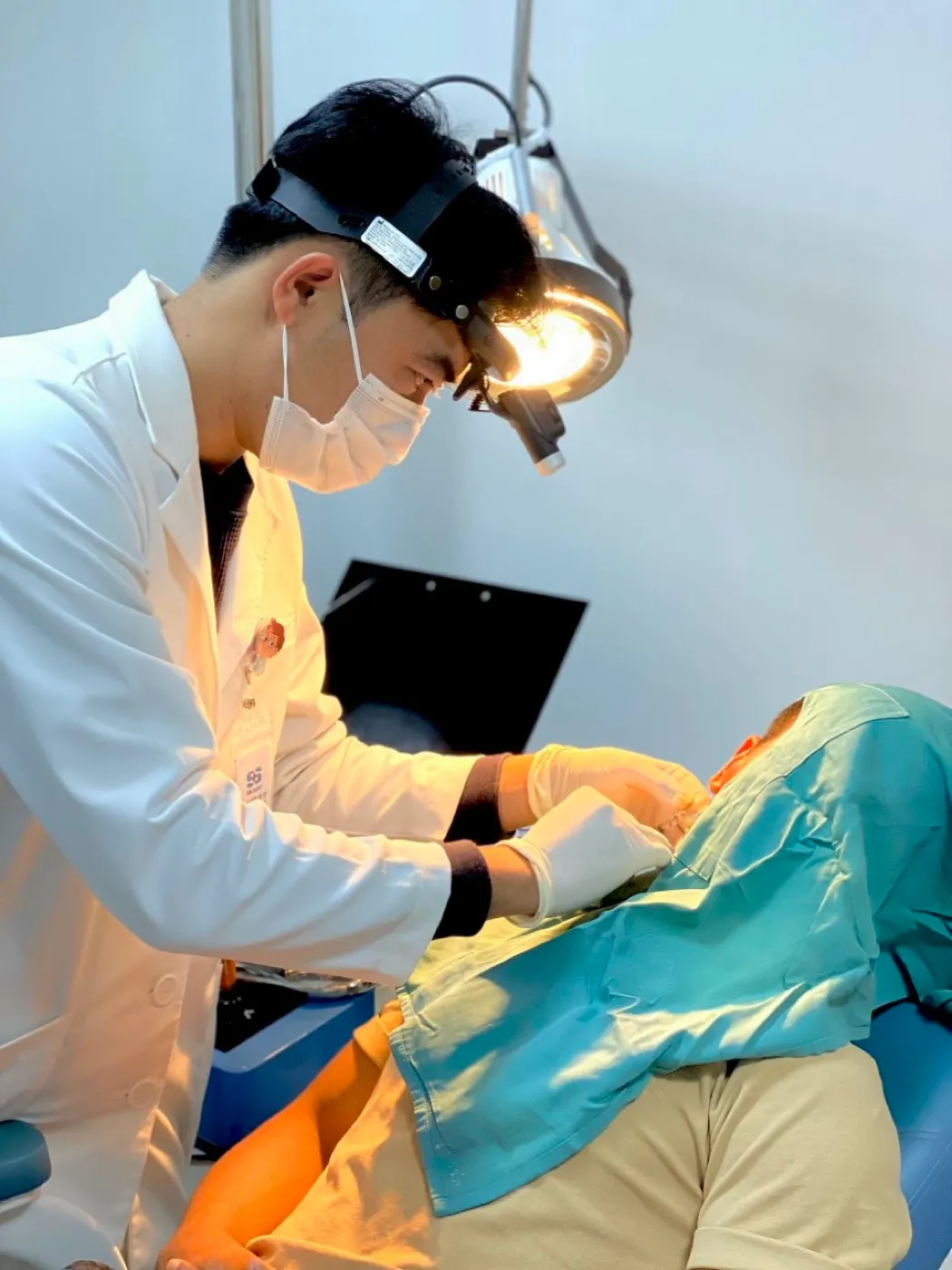 Bác sĩ Đức khám tai mũi họng bằng đèn soi trán