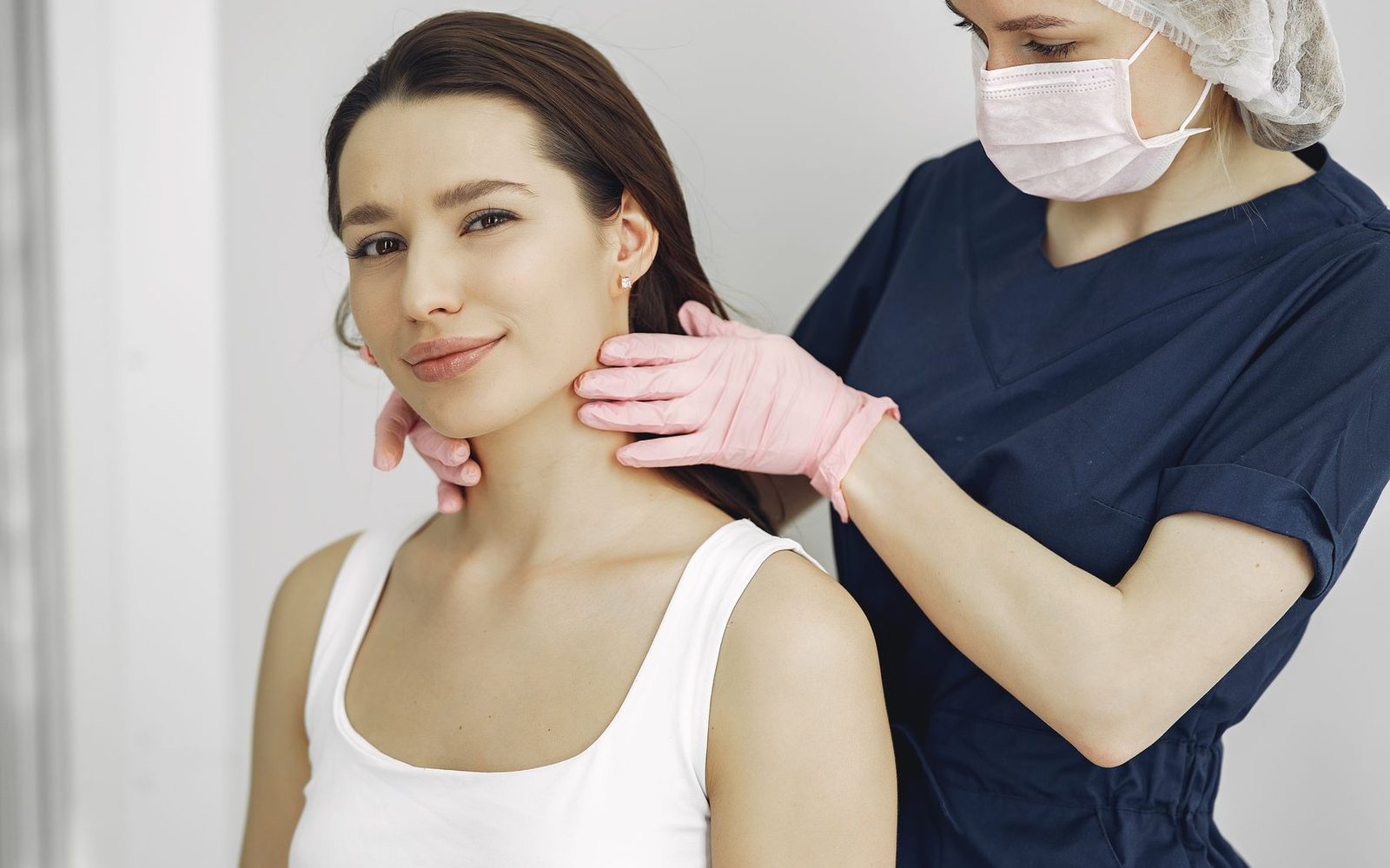 Bác sĩ thăm khám vùng cổ để kiểm tra tuyến giáp