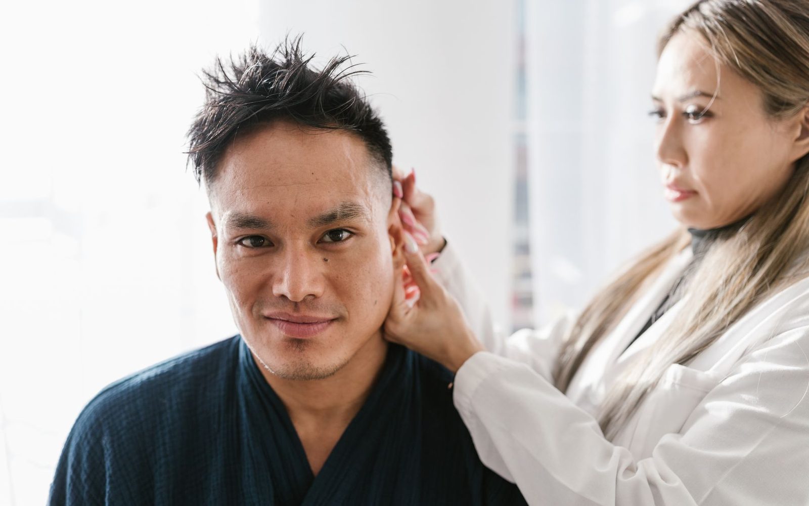 Bác sĩ sờ khám vùng trước tai và góc hàm của người bệnh
