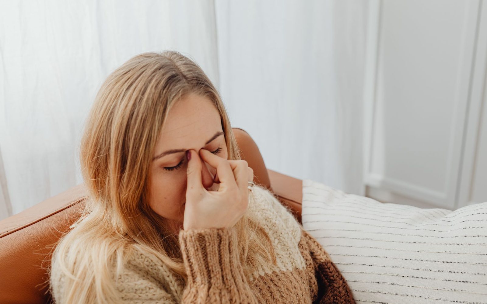 Người phụ nữ ôm vùng sống mũi vì đau tức mặt do viêm xoang